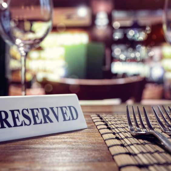 Reserved sign on restaurant table with bar background